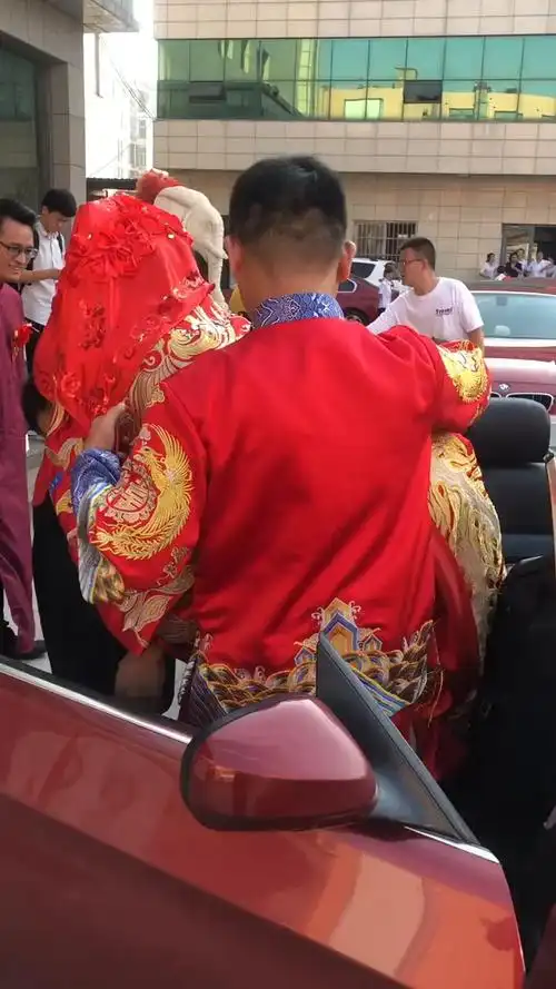 新郎抱着漂亮的新娘上车了.