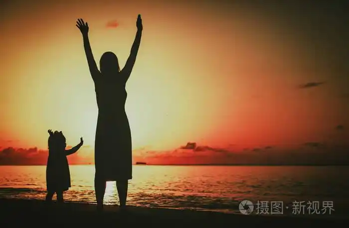 快乐妈妈和小女儿在日落时的剪影