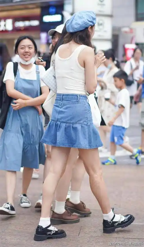 小姐姐一件白色背心搭配蓝色牛仔短裙加上可爱的蓝色小帽
