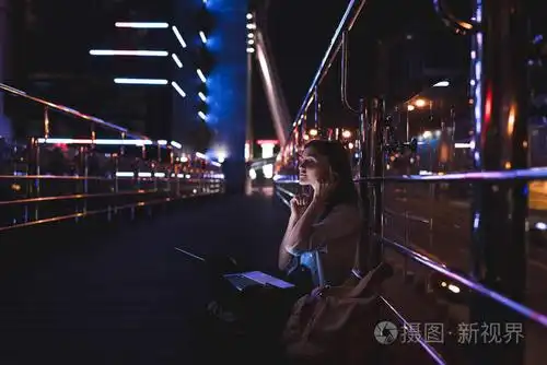 女用膝上型电脑耳机听音乐的侧面在城市街道上的夜晚