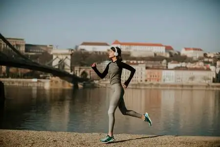 美丽的年轻女子运动员在布达佩斯的海滨奔跑, 匈牙利照片