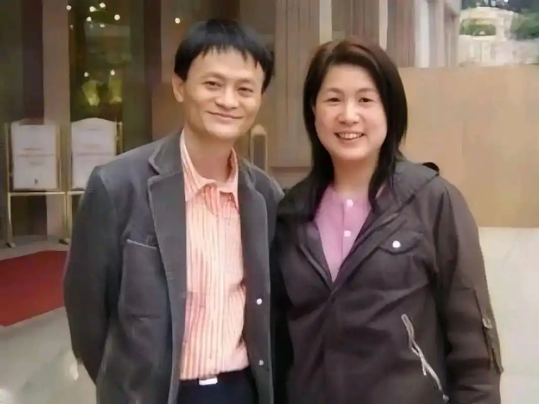 马云穿着黑色的西装外套和牛仔裤,搭配了白色的衬衫和鞋子,看起来干练