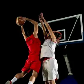 在黑色背景上孤立的行动中的篮球比赛体育运动员