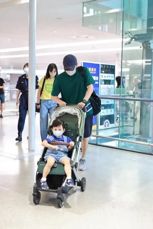王阳一家三口亮相上海机场他上身穿绿色t恤下身搭配黑色短裤
