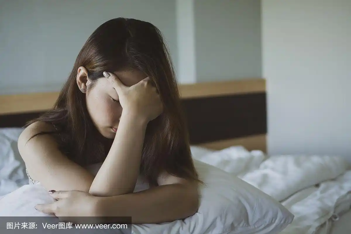 沮丧的女人坐在床上.她疲惫不堪,饱受失眠之苦