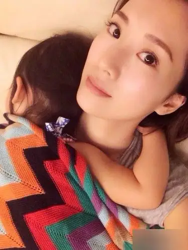 李念晒出怀抱女儿的照片,并幸福的称:"这个小胖子就像一个围巾一样,把