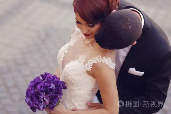 新郎的脖子亲吻他的新娘照片-正版商用图片0oupo5-摄图新视界