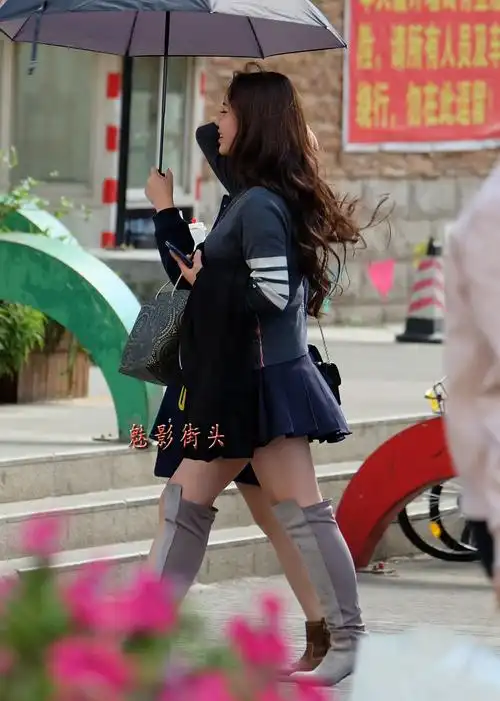 手缕秀发回眸一笑百媚生超短裙高筒靴子的美女