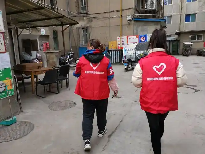 社区工作人员在院落里排查隐患,向居民们发放宣传资料.