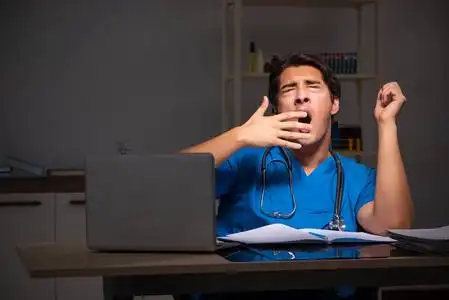 年轻英俊医生夜班在医院照片