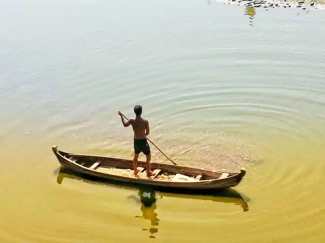 撑着竹杆划船的船夫