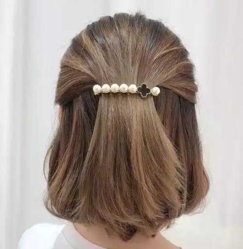 把后侧头发拿出一束,扎个低马尾,然后用蝴蝶结发饰固定住,侧面和后面