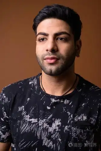 年轻英俊的印度人反对棕色背景