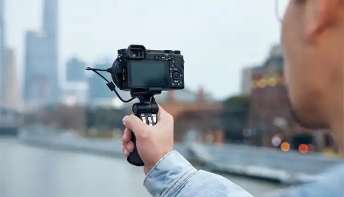 摄图网_502368015_banner_青年男性手拿相机拍摄旅游视频(企业商用)