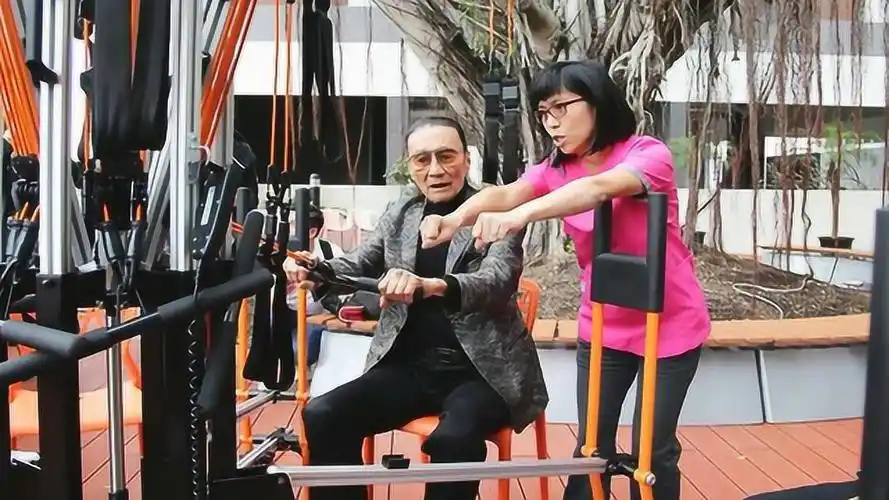 82岁谢贤穿西装试玩健身器材拉伸筋骨 精气神十足