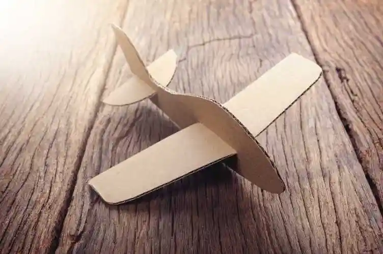 木制背景下的纸板飞机