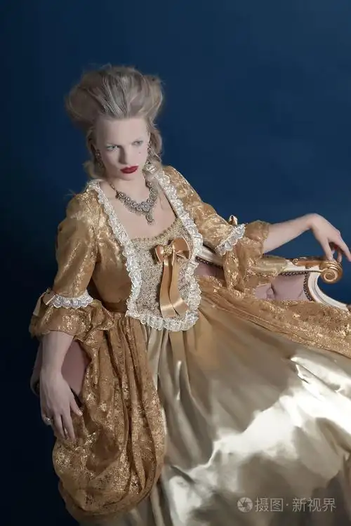 复古的巴洛克式时尚女人穿着金色衣服.坐在文塔