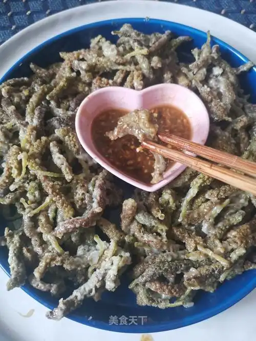 蒸好的构树花蘸酱汁,吃起来酸酸辣辣的,软软糯糯的.