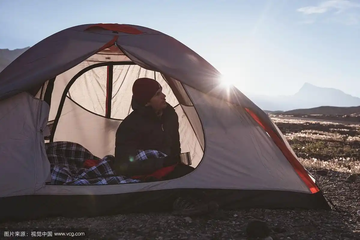 一个阳光明媚的日子,一个男人在帐篷里放松