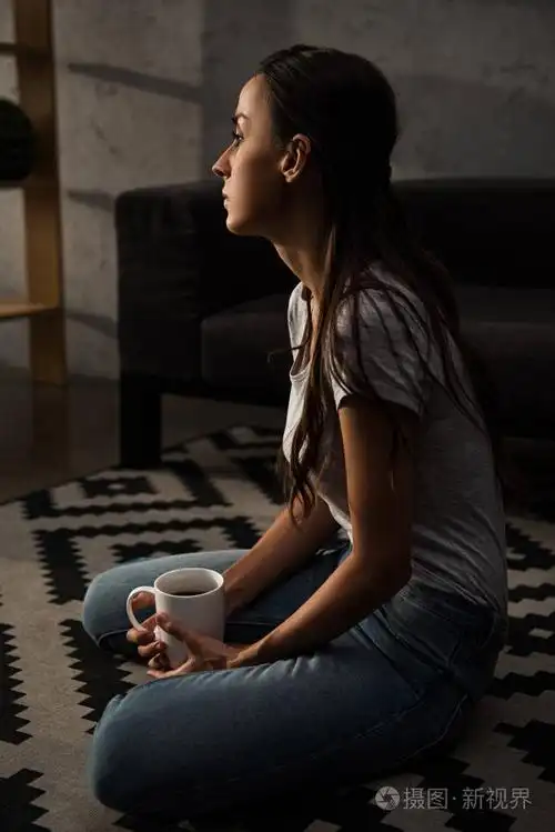 伤心寂寞的女人坐在地板上喝着咖啡