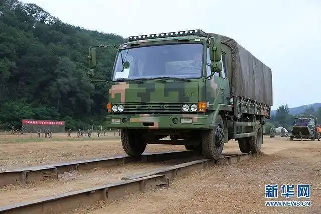 一辆军用运输车正在通过难度系数较大的交叉轨道桥项目.