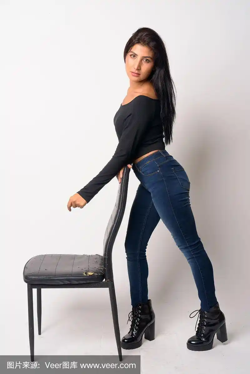 年轻美丽的波斯女子倚靠在椅子上的全身照片