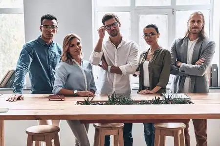 商务人士团队在木桌在创造性的现代办公室工作室摆姿势和看着相机照片