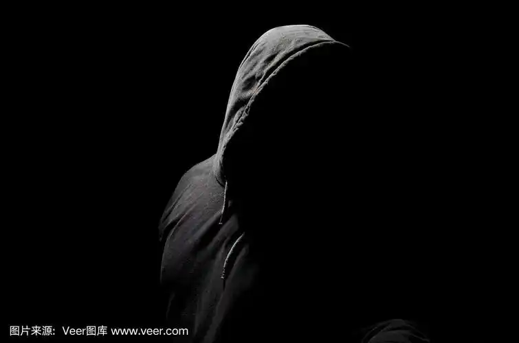在黑色背景上戴着兜帽的无名人士