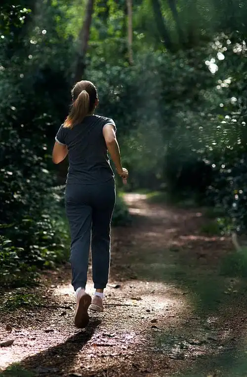 一个女人在野外越野跑期间的后视图图片下载