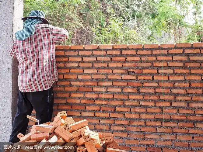 建筑工人在建筑工地用水泥砌砖墙.建筑和行业概念