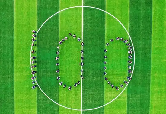 埭溪镇上强中学学生手捧绿植在学校操场上摆成100字样队形.何伟卫 摄