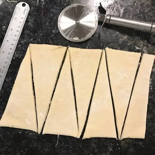 然后将折好的面片擀至4mm厚,用刀修去不规整的边缘,切割成底边10cm,高