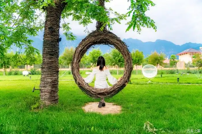 一个人在院落里好自在,绿绿的草坪,编织的吊椅,悠闲自得!