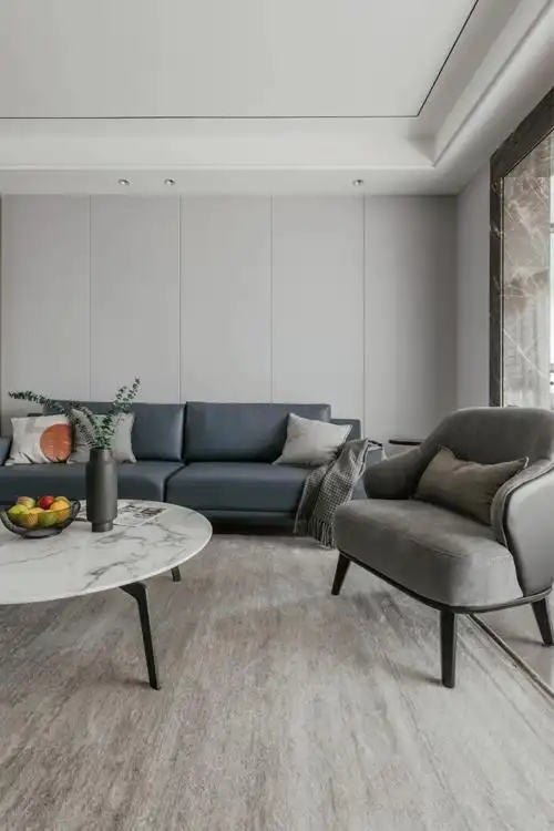 背景选用浅灰色极简线条硬包,以藏蓝色沙发相配