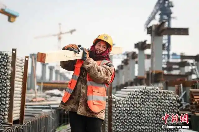 一名女性工人正在搬运木料. 中新社记者 贾天勇 摄