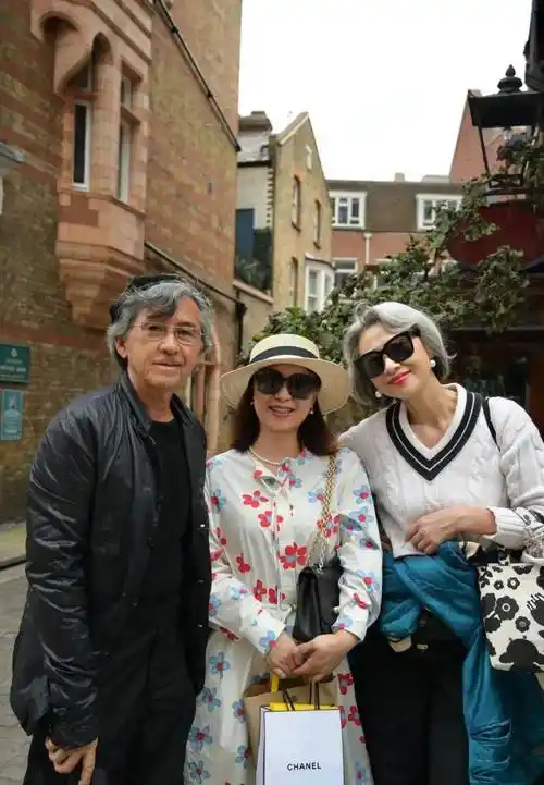 林子祥叶倩文在国外街头跟路人合影,白发苍苍都真实的老了,一个沧桑