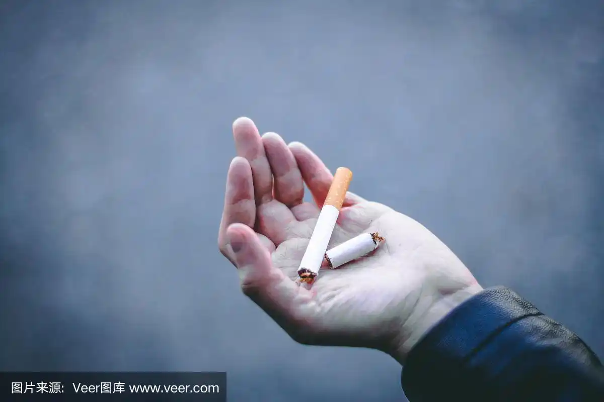 一个年轻的手拿着一根断了的香烟的特写镜头