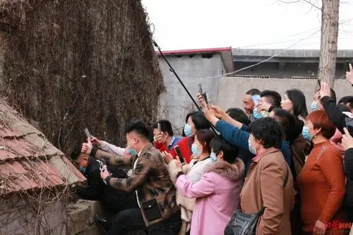 在"拉面哥"家院外向内围观及直播的人群