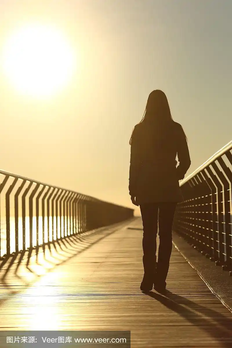 夕阳下,忧伤的女人独自走着剪影