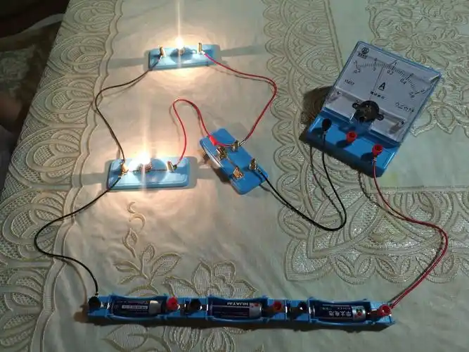 利用实验器材连接两个灯泡的并联电路,连入电流表,观察电流表的读数