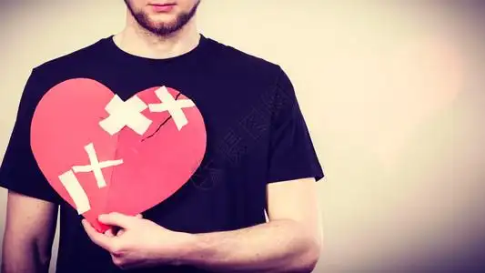 碎片彩纸心碎的概念悲伤男人拿着爱标志人类感觉被石膏所恢复情人节