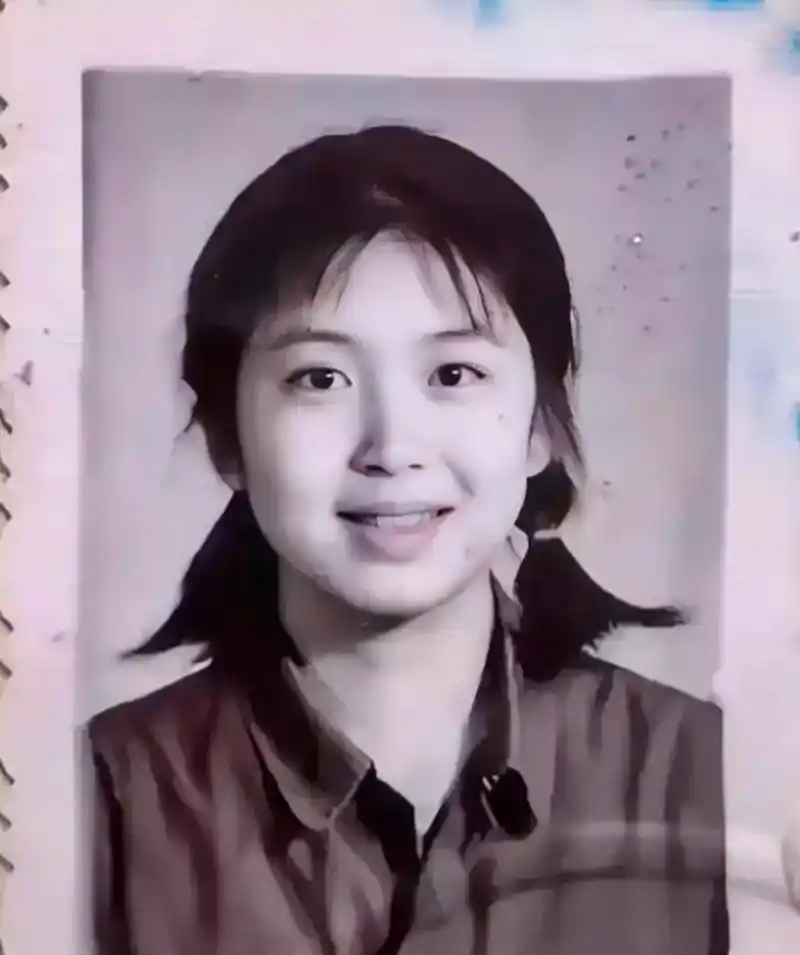 80年代的一张老照片,一个不到20岁的女高中生的毕业照,她纯真的笑容和