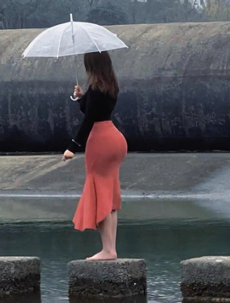 雨中漫步,打着伞的红裙子美女.