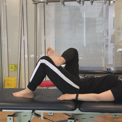 动作二:把疼痛的腿放于另一条腿上,用另一个手把膝盖向中线拉伸,感觉