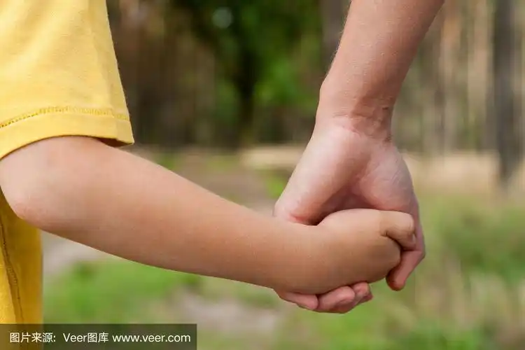 母亲在户外牵着儿子的手