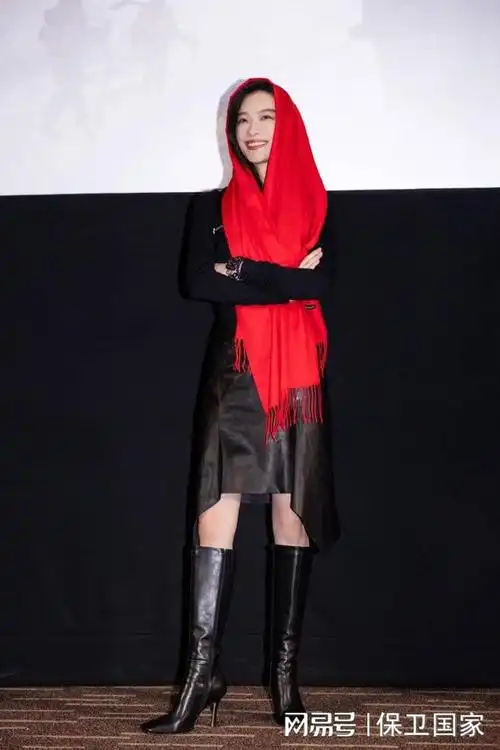 倪妮皮裙搭长靴又酷又飒 头披红围巾笑容灿烂