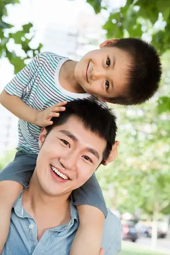 小男孩坐在爸爸肩上