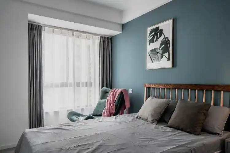 卧室的装修在用色上与客厅保持一致,蓝灰色的墙壁,颜色看起来非常素雅