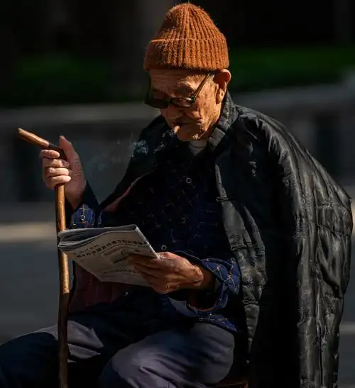 暖暖的阳光到西安大雁塔景区拍照看到一束侧光照在一个看报纸的老人