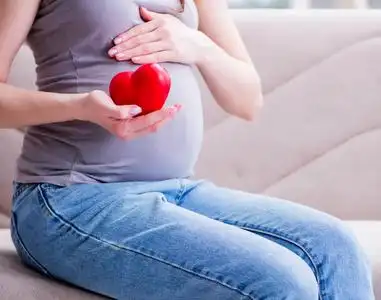 肚子大的孕妇坐在家里的沙发上照片